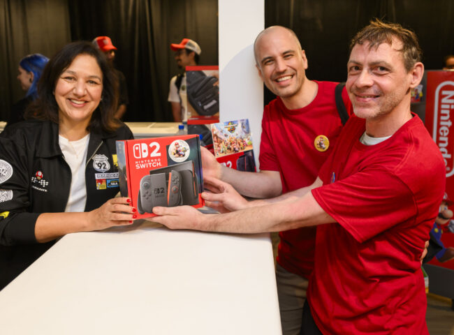 Представниця Nintendo of Canada вручає консоль Switch 2 покупцям на події в Торонто