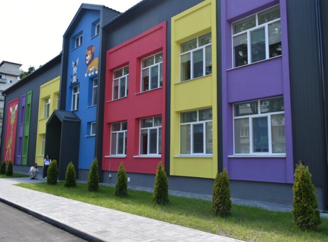 Фото: Оболонська районна в місті Києві державна адміністрація. CC BY 4.0 https://creativecommons.org/licenses/by/4.0/ . Джерело: https://obolon.kyivcity.gov.ua/galleries/na-oboloni-ziavylos-mistse-shchaslyvoho-dytynstva-novyi-dytsadok-206-vzhe-vidkryto . Фото відкриття 04.07.2025; технічне масштабування. Кольоровий фасад дитячого садка №206 на Полярній у Києві